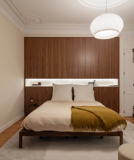 Dormitorio con cabecero integrado en panelado de madera de y hornacina LED.