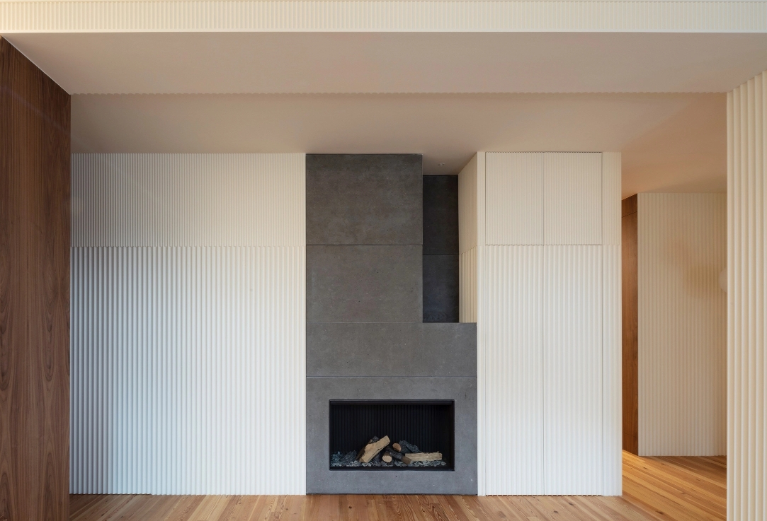 Fireplace built into gray wall flanked by white slatted panel cabinet.