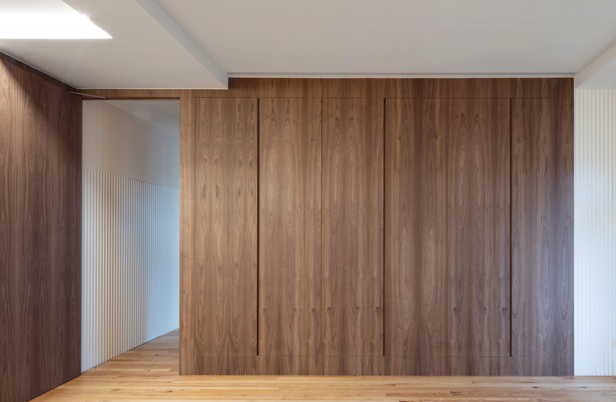 Built-in wooden closet integrated in hallway with wooden floor.