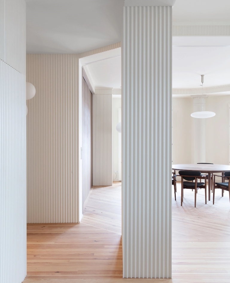 Dining room with white slatted pillars and round wooden table