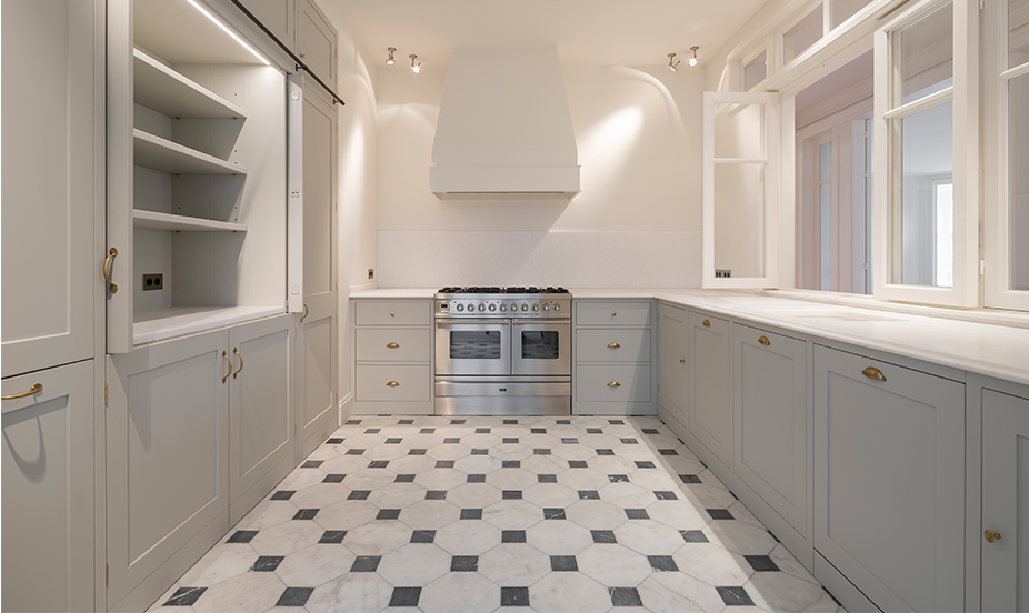 Bright kitchen with gray cabinets and a classic two-tone black and white geometric ceramic tile floor.