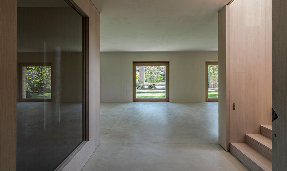 Modern and diaphanous space characterized by a gray microcement floor, a clean and modern architectural style.