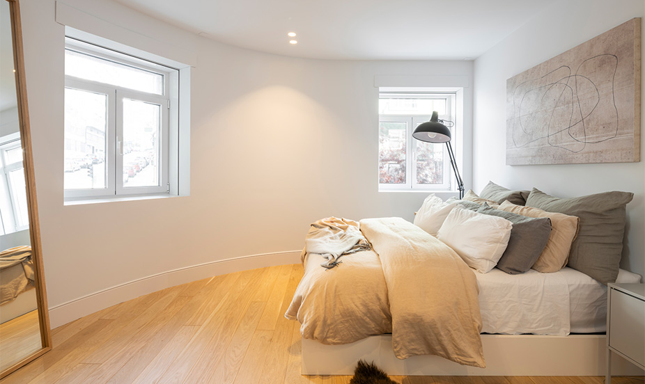 A living area with light-colored tones and hardwood floors, featuring an open layout that facilitates easy movement.